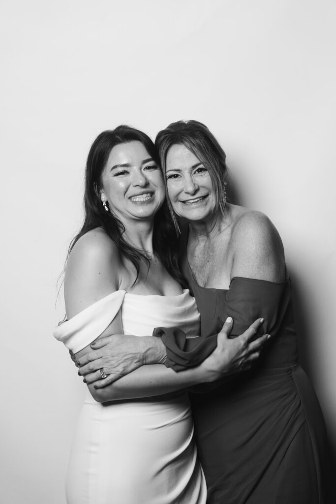 Bride and mother of the groom embracing during wedding guest portrait experience in Cleveland, Ohio.