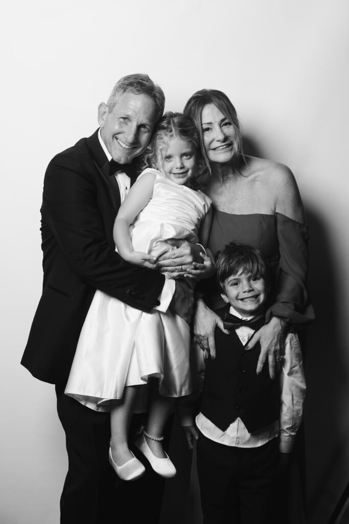 Grandparents and grandchildren smiling during heirloom-style guest portrait at Cleveland wedding.
